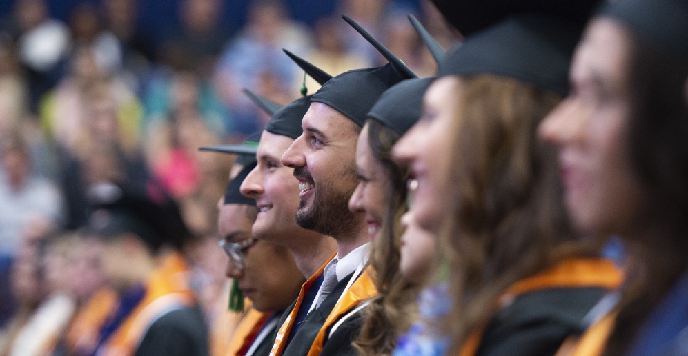 A diverse students sitting down at Cal State Fullerton graduation ceremony 