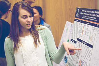 CSUF Student pointing at the presentation board