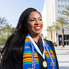 Young woman waving during the 2016 CSUF commencement ceremony