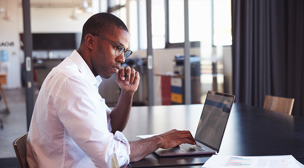 African American man working on a computer and paperwork