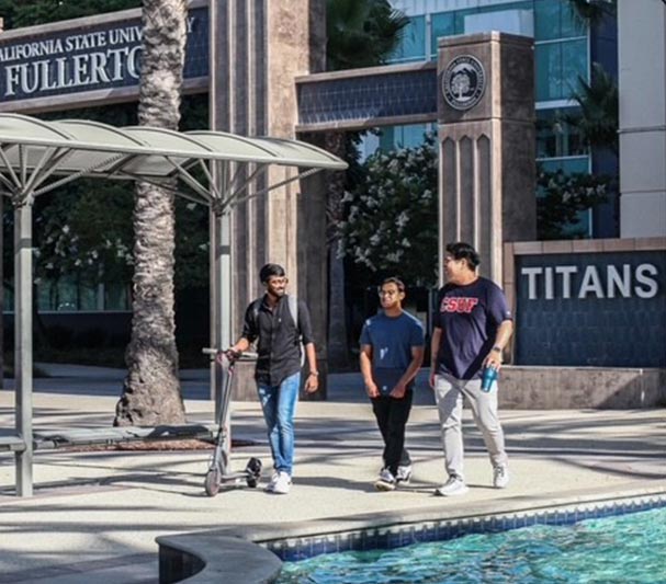 Three CSUF students walking by the fountain outside Langsdorf Hall