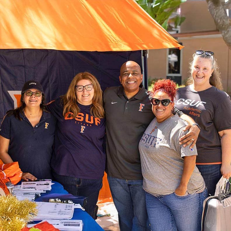 Four University Extension team members with President Ronald Rochon