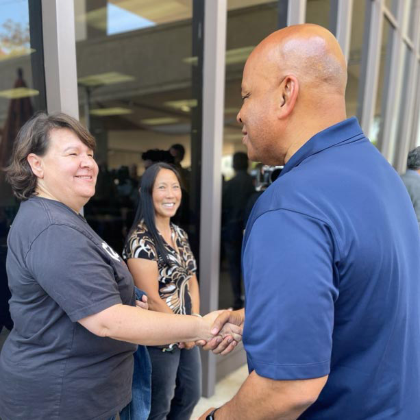 University Extension team member shaking hands with President Ronald Rochon