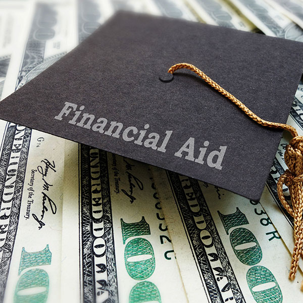 A graduation hat with hundred dollar bills